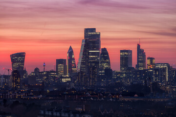 The modern skyline of the financial district City of London, United Kingdom, during dusk with a red and orange colored sky