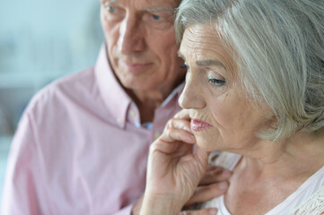 Portrait of unhappy senior couple posing at home