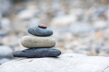 A background of pebbles by the ocean on the beach with copy space, a symbol of peace and relaxation.