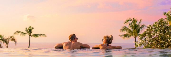 Fototapeta na wymiar Panoramic photo of couple in pool enjoying tropical vacation by sunset