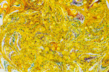 Smeared yellow paint stain with glitters.Abstract work of art. Beautiful jelly texture.