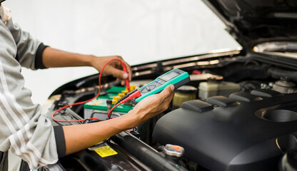 Fototapeta na wymiar A technician is checking the car battery for availability.;