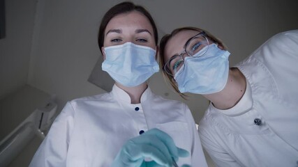 POV shot of patient seeing female dentist with assistant during treat procrdure