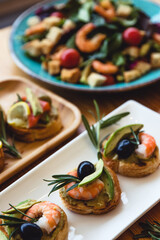 Appetizer canape with shrimp and cucumber on plate on table close up