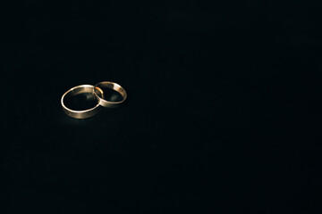 Two wedding rings on black background