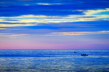 two boats on blue sea with twilight cloudy sky