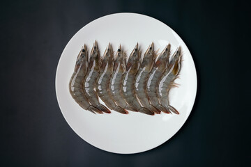 raw freshness shrimps on white dish with black table background preparing for food