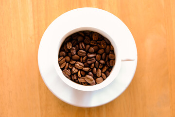 coffee beans in cup coffee on table wood background