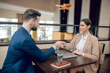 Young woman in a beige suit having an interview with a manager