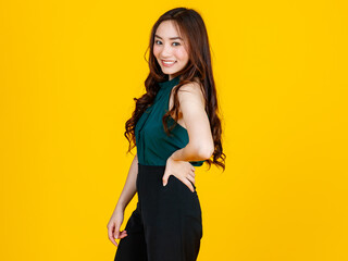 30s cute and charming curly hair Asian female brunette pose to camera with a joyful and positive gesture for advertising use purpose. Taken with studio flash isolated on yellow background