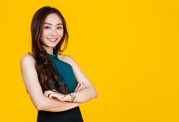 30s cute and charming curly hair Asian female brunette pose to camera with a joyful and positive gesture for advertising use purpose. Taken with studio flash isolated on yellow background