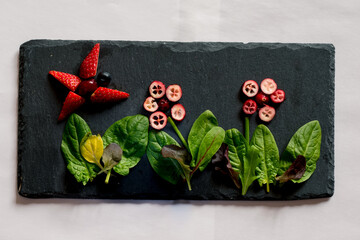 creative meal ideas from strawberry for children in black shale background