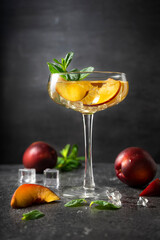 author's cocktail with nectarine fruit in a high martini glass. low key, vertical position. Concept for menus and bars