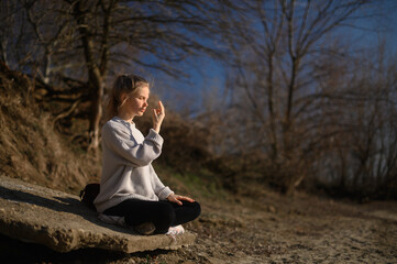 Practice of meditation and interaction with nature. Girl near river