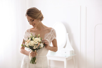 Bride in beautiful wedding dress with bouquet indoors. Space for text