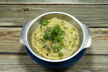 Traditional Chinese steamed egg topping with fresh coriander serving in the stainless bowl. Famous breakfast menu in Asia. 