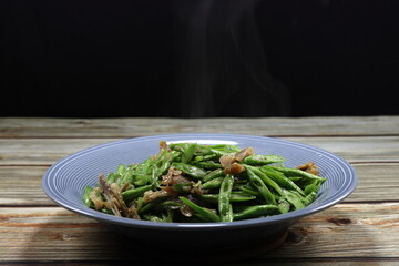 Traditional fried and stirred sliced green bean (Yardlong bean) mixed with chopped chicken serving on the plate. 