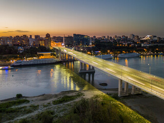 Fototapeta premium Rostov-on-Don, Russia - July 06, 2020: Voroshilovsky bridge at sunset and view of the left bank of the Don river, Rostov-Arena stadium with text Russia