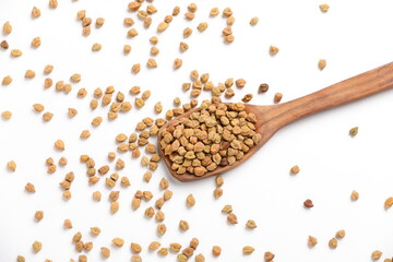 Dry raw organic chickpeas in a wooden spoon isolated on white background.
