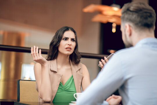Young woman talking to a man and looking disappointed