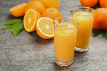 Delicious orange juice and fresh fruits on grey table. Space for text
