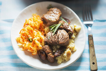 Teriyaki pork loins in whiskey, coffee and rosemary sauce, served with couscous and salad