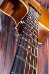 Obraz premium Close up of acoustic guitar. Acoustic guitar against an old wooden background
