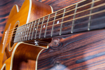 Obraz premium Close up of acoustic guitar. Acoustic guitar and an old wooden background