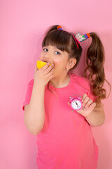 Funny little girl with fruit citrus fruit on pink  background.