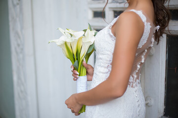wedding bouquet calla lillies in hads of bride
