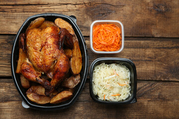 Plastic containers with different dishes on wooden table, flat lay. Food delivery service