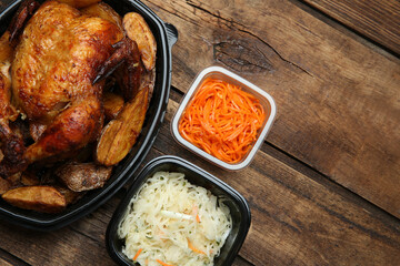 Plastic containers with different dishes on wooden table, flat lay. Food delivery service