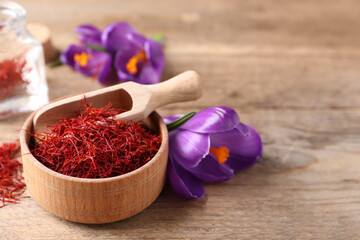 Dried saffron and crocus flowers on wooden table. Space for text