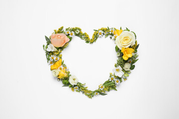 Beautiful heart made of different flowers on white background, top view