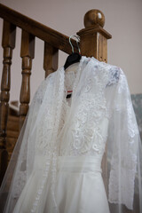 The wedding dress is hanging on the stairs.