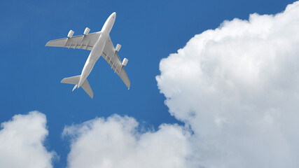 Fototapeta na wymiar Passenger commercial airplane flying above head as shot from the ground in deep blue cloudy sky