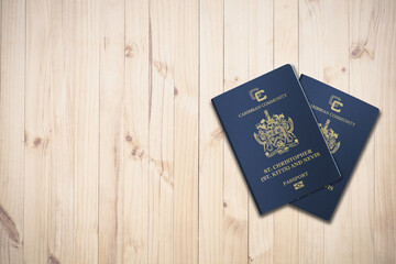 Two Saint Kitts and Nevis passports on a wooden background, citizenship by investment
