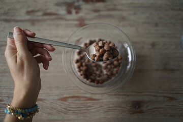 chocolate cereal in glass bowl on wooden background
