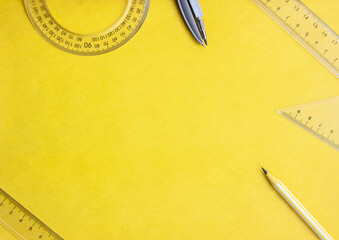 Flat lay geometry, rulers and compasses on a yellow background, copy space
