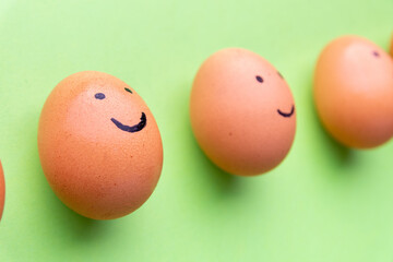 Smiling and sad eggs on a green background