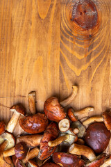 Fresh boletus mushrooms on wooden table from above. Copy sapce