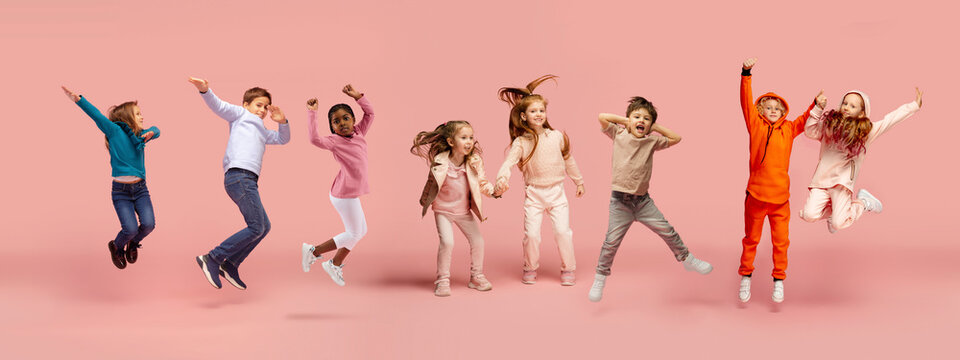 Little and happy kids gesturing isolated on pink studio background. Human emotions, facial expression concept