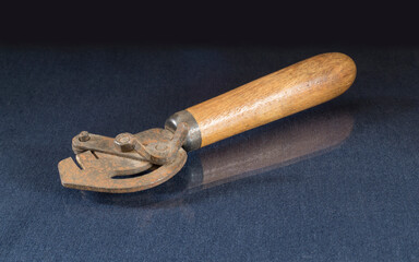 A rusty carpenter's tool is lying on a glass table