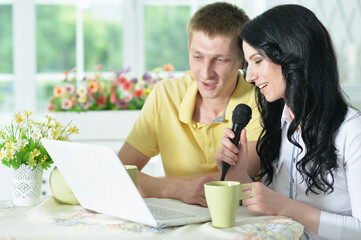 Portrait of happy young couple singing karaoke