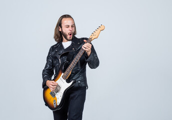 emotional bearded rock musician playing electric guitar in leather jacket, music