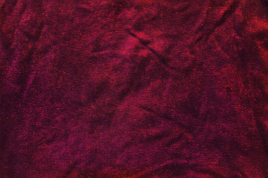 Spotted, crumpled, glowing background. Red texture.
