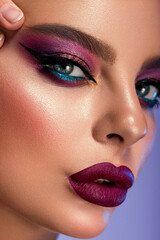High Fashion model multicolor lips and face woman in colorful bright neon uv blue and purple lights, posing in studio, beautiful girl, glowing make-up, colorful make up. Glitter Vivid neon makeup