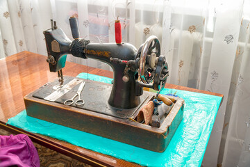 Vintage sewing machine and scissors on the table