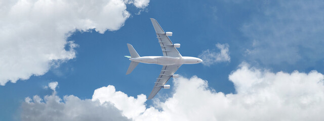 Ultra wide photo of passenger commercial airplane flying above head as shot from the ground in deep blue cloudy sky
