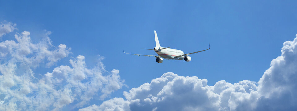Ultra wide zoom photo of passenger airplane taking off in deep blue sky and beautiful clouds